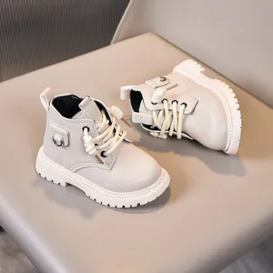 Detail view of cream children's boots with matte leather, thick soles and side ring detail