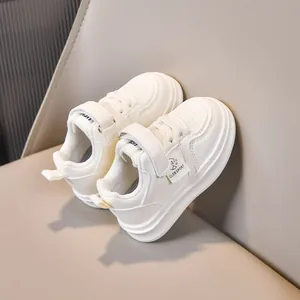 Detailed macro view of white children's leather sneakers featuring velcro strap and soft lining