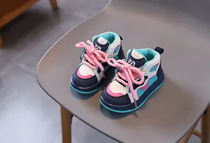 Detail von High-Top Kindersneakers mit dunkelblauen Panels und dicken rosa Schnürsenkeln