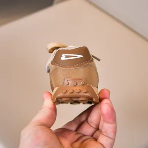 Detailansicht brauner Kinderschuhe mit weißem Herzlogo und strukturierter Gummisohle