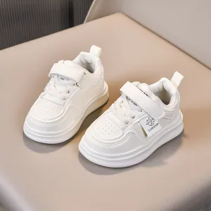 Detail of children's white leather sneakers featuring velcro strap and non-slip rubber sole