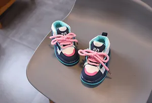 Detailansicht hoher Kinderschuhe mit dicken rosa Schnürsenkeln und bunten Farbelementen