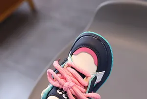 Nahaufnahme von Kinderschuhen mit bunten Einsätzen und dicken gewebten Schnürsenkeln