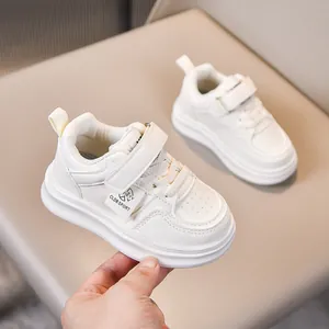 Detail view of white toddler sneakers with Velcro straps and thick anti-slip rubber soles