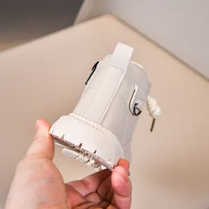 Detail shot of cream-colored children's boots with non-slip thick soles and stitching