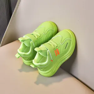 Detail of neon green kids sneakers with velcro straps and breathable mesh material