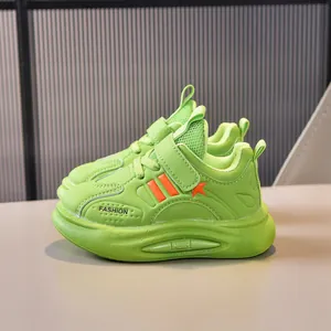 Detail of neon green kids' sneaker with orange star patterns and velcro strap closure