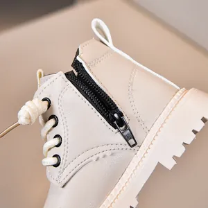 Detail of children's beige leather boots with side zipper and thick rubber sole