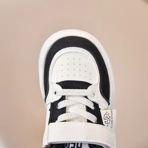 Detail of kids leather sneakers with breathable toe perforations and velcro strap