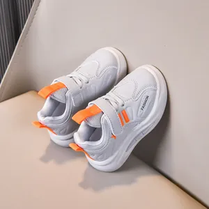 Detailed view of kids' sports shoes with orange pull tabs and velcro closure