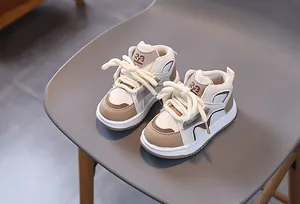 Detail von Kinder-High-Top-Sneakern in Beige und Kaffee-Patchwork mit dicken Baumwollschnüren