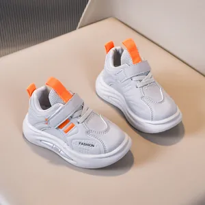 Detail of children sneakers with breathable mesh, velcro strap and orange pull tabs