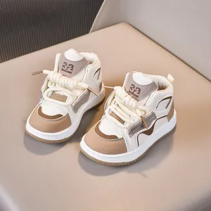 Λεπτομέρεια από παιδικά sneakers με μπεζ σχέδιο και χοντρά υφαντά κορδόνια