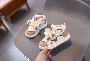 Detail von High-Top-Kindersneakern in Beige und Braun mit Nummer 32 und Gummisohle