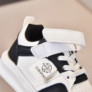 Detailed macro view of white kids sneakers featuring velcro straps and side logo label