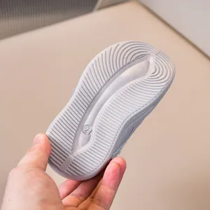 Detail shot of non-slip flexible sole with size 21 marking on grey toddler sports shoes