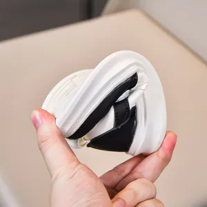 Detail showing the flexible and soft rubber sole of kids' black and white casual shoes