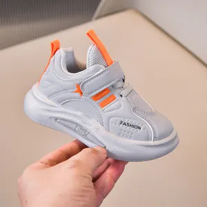 Detail view of children sneaker with grey mesh upper and bright orange accents