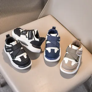 Dettaglio di scarpe da ginnastica per bambini in nero, blu e marrone con velcro