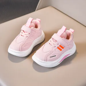 Pink and white kids athletic sneakers with orange stripes and velcro strap closure