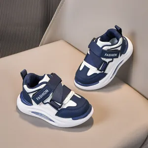 Dettaglio ravvicinato delle sneakers blu navy e bianche per bambini con velcro