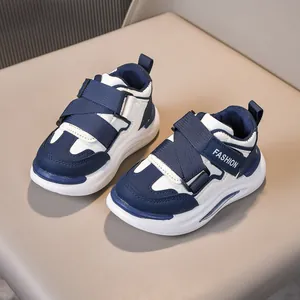 Vista dall'alto di scarpe sportive blu e bianche per bambini con chiusura a strappo