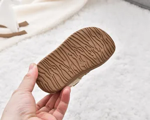 Close-up of brown anti-slip sole with wave pattern and size 23 mark on kids shoe