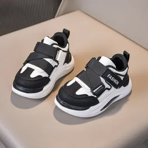 Dettaglio di sneakers in pelle per bambini con velcro e design a contrasto nero e bianco