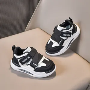 Dettaglio di sneaker per bambini in pelle bianca e nera con chiusura a velcro
