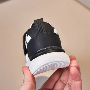 Vista posteriore di sneaker in pelle nera per bambini con linguetta e suola spessa