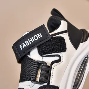 Dettaglio di sneakers per bambini con cinturino in velcro, testo FASHION e cuciture