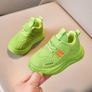 Kids sports shoes in neon green and orange with fashion logo and velcro strap