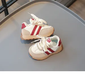 Draufsicht auf Kleinkind-Sneaker mit cremefarbenem Obermaterial und roten Streifen