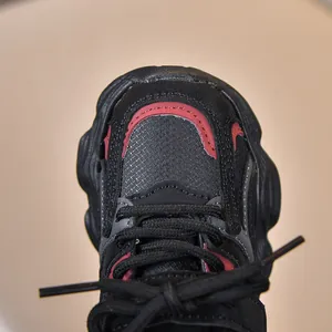 Détail de la basket pour enfants en maille noire avec des bordures rouges contrastées