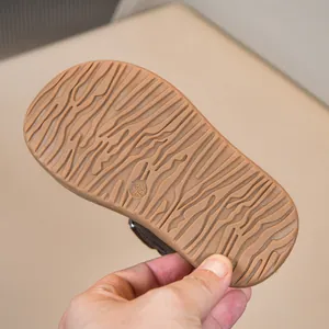 Dettaglio della suola antiscivolo marrone delle scarpe da ginnastica invernali per bambini