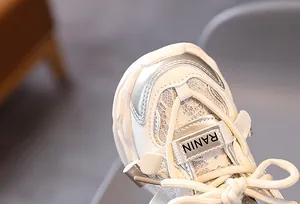 Detailed macro of kids sneaker mesh with floral lace texture and silver leather accents