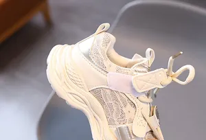 Detailed close-up of girls cream mesh sneakers featuring floral lace and velcro strap