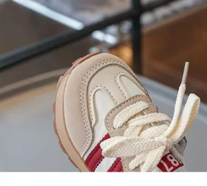 Makroaufnahme atmungsaktiver Kinder-Sneaker in Beige mit roten Streifen und Wildleder