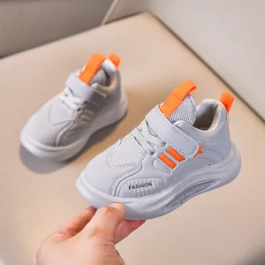 Kids' non-slip sports shoes in light grey with orange accents and velcro strap