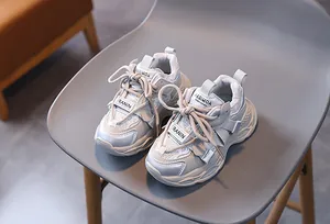 Detail of breathable mesh and synthetic leather panels on beige kids' chunky sneakers