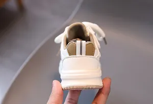 Dettaglio del tallone di sneaker per bambini con pelle kaki e linguetta riflettente