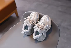 Detail of mesh kids sneakers with velcro strap and breathable fabric in beige