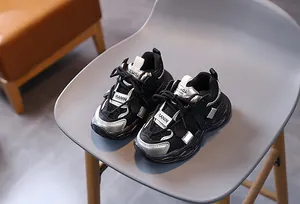 Detailed close-up of kids black mesh sneakers featuring silver reflective accents and thick soles