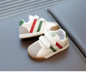 Detail of waterproof white leather toddler shoes with red and green stripes and hook-and-loop straps