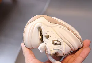 Dettaglio macro delle sneakers flessibili color crema per neonati con suola morbida