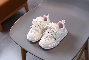Dettaglio di sneaker per bambini con lacci spessi in cotone e ciondoli 3D carini