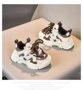 Detalle de zapatillas de malla transpirable para niños con suela gruesa y adornos marrones