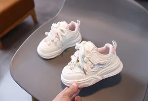Dettaglio di sneakers per bambini con motivo a cuore e decorazione di bambola cartone