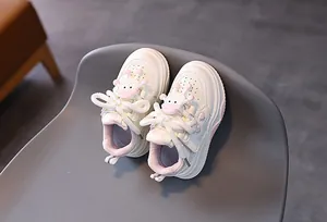 Dettaglio scarpe da ginnastica bianche per bambini con cuori rosa e vitello 3D sulla linguetta
