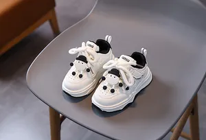 Dettaglio delle sneakers per bambini con pupazzo di neve e design a blocchi di colore bianco e nero
